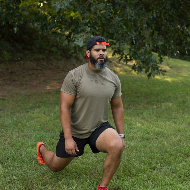 Physical Fitness Trainer, Rich Medlin, performs a standard lunge during an outdoor workout.