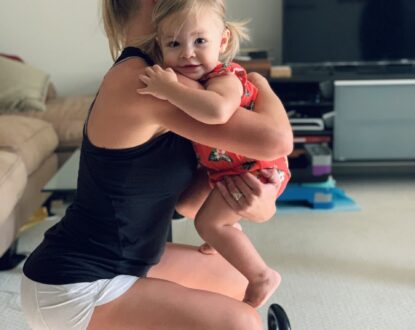 Mom performing squat while holding their child.