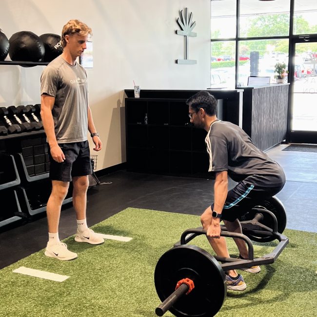 Trainer Liam Raaen works with a client on improving his deadlift at Oak and Iron