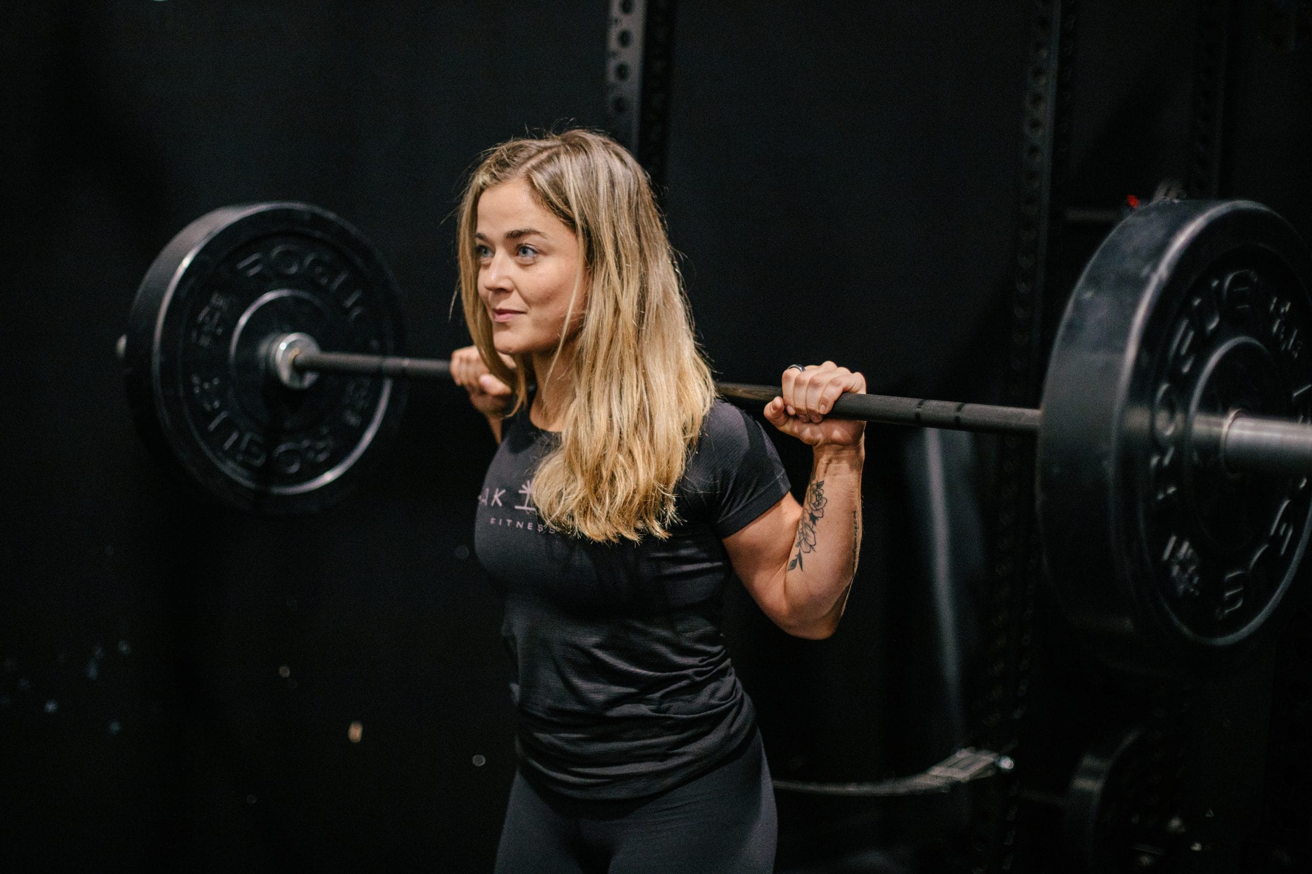Why Women Should Lift Heavy Weights 1 Rachel Nicholson, CSCS certified strength coach and personal trainer with a barbell racked across shoulders. Why Women Should Lift Heavy Weights